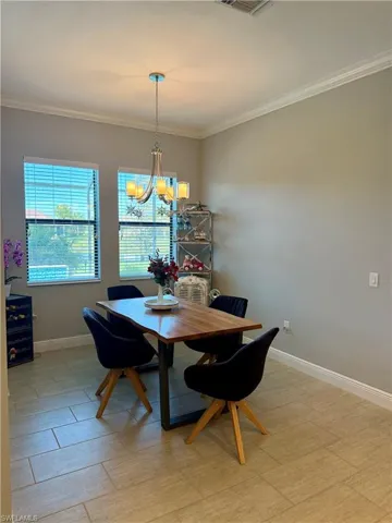Dining area with a chandelier and ornamental molding