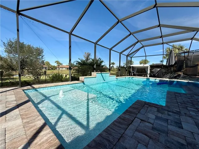 Outdoor pool featuring glass enclosure and a sunroom