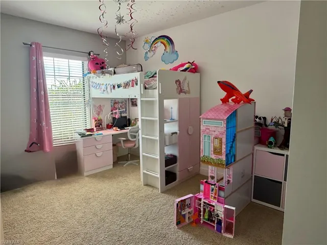 Bedroom featuring a desk and light colored carpet