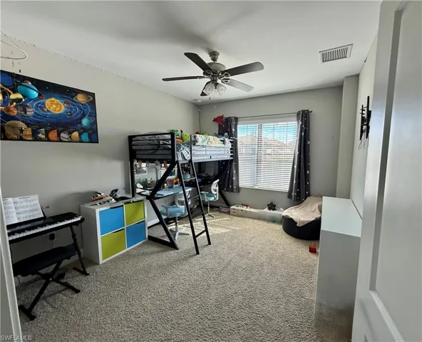 Carpeted bedroom featuring ceiling fan