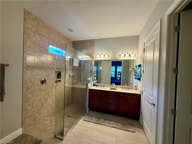Full bathroom featuring walk in shower and double vanity