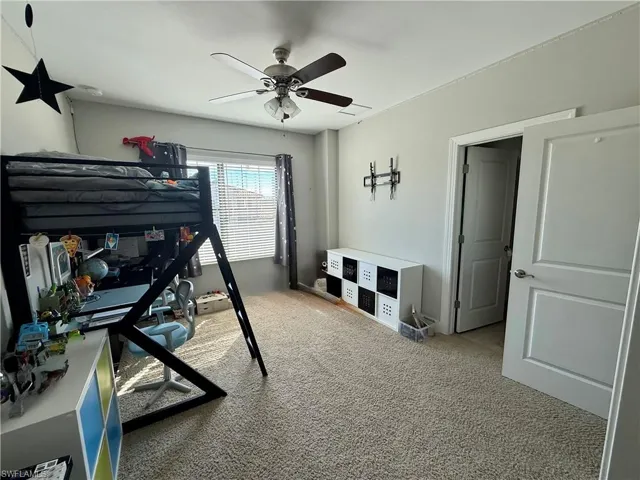 Bedroom featuring light colored carpet and ceiling fan