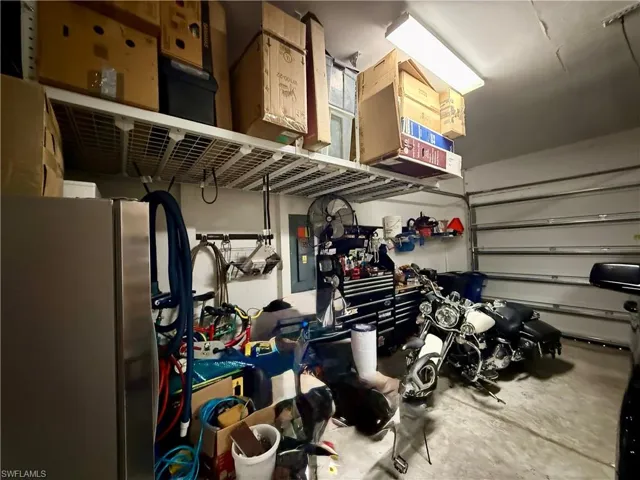 Garage featuring freestanding refrigerator and electric panel