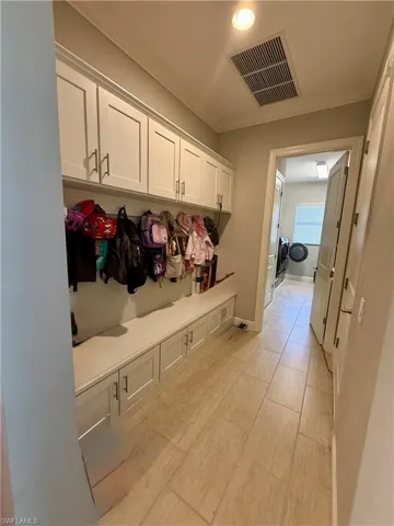 Mudroom with baseboards and crown molding