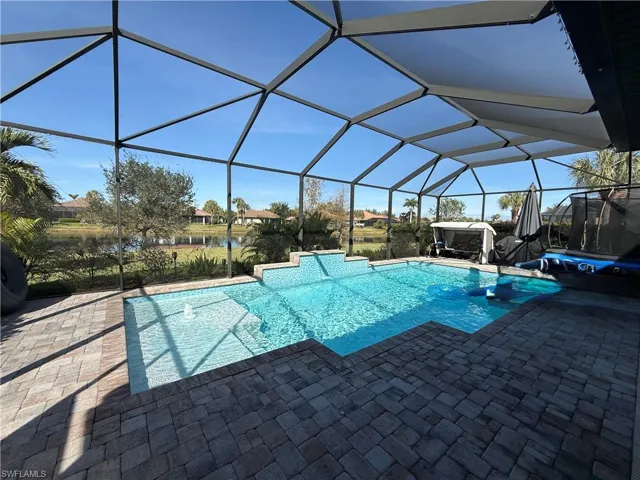 Swimming pool featuring a sunroom, a lanai, and a patio