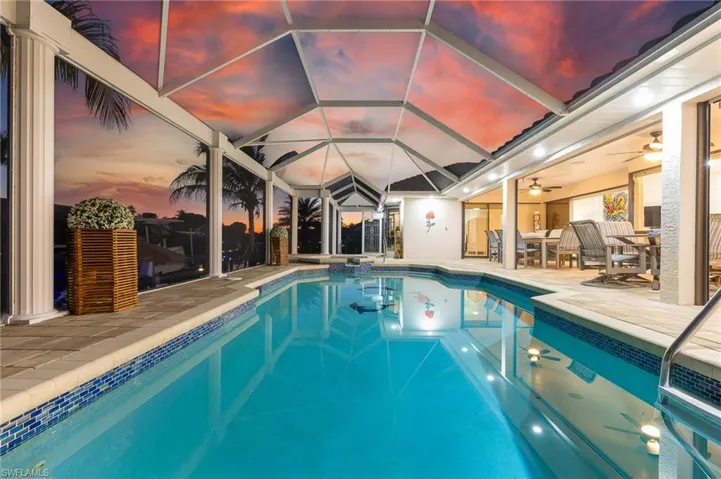 View of pool with a sunroom and a pool with connected hot tub