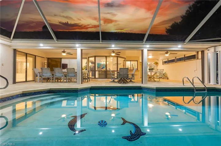 Indoor pool with a patio, outdoor dining space, a lanai, and a ceiling fan