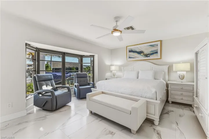 Bedroom with ceiling fan and marble finish flooring