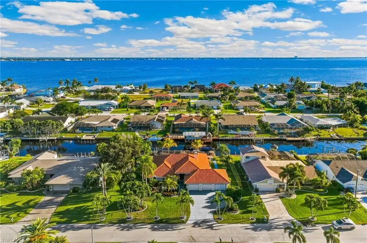 Aerial perspective of suburban area featuring a nearby body of water