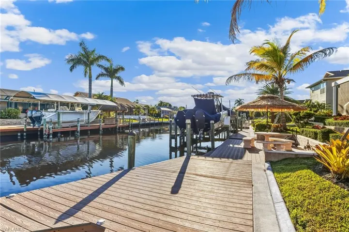Dock area with boat lift, a residential view, and a water view