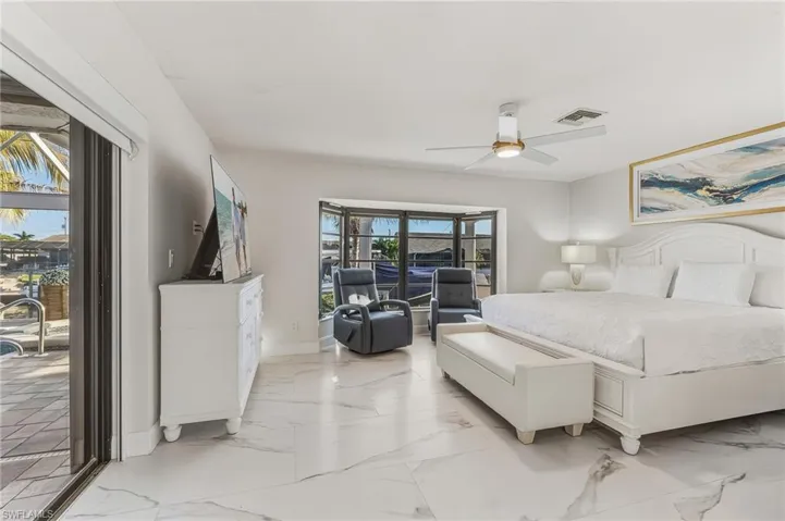 Bedroom featuring access to outside, a ceiling fan, and light marble finish floors
