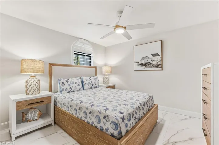 Bedroom featuring light marble finish flooring and ceiling fan