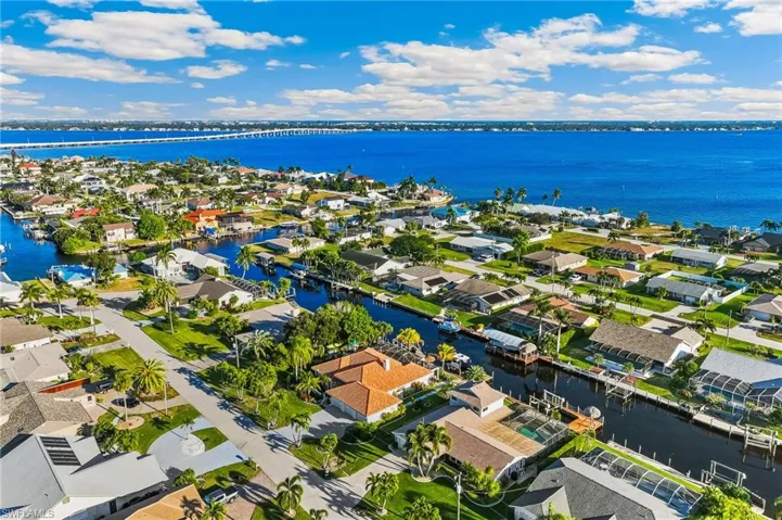 Aerial perspective of suburban area featuring a nearby body of water and a notable bridge