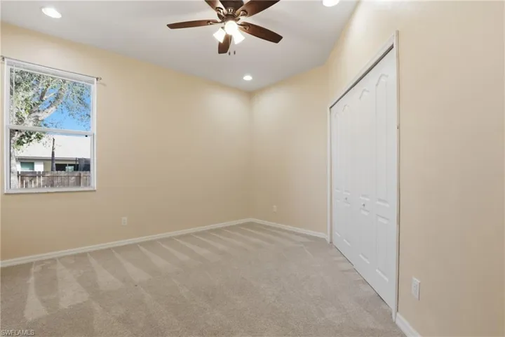 Unfurnished bedroom featuring light carpet, a ceiling fan, recessed lighting, and a closet
