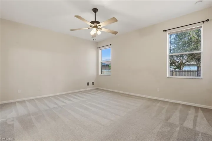 Unfurnished room with light carpet and ceiling fan