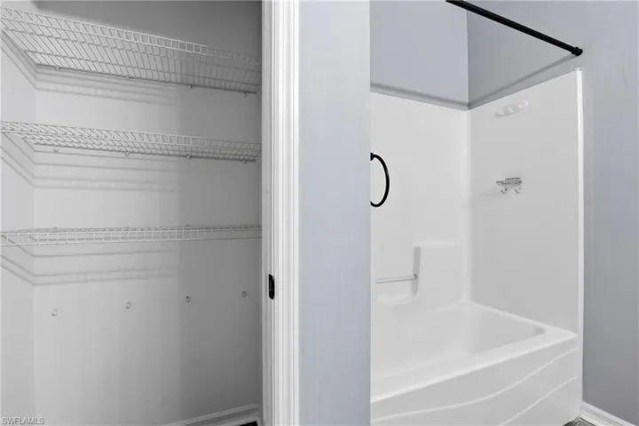 Bathroom with shower / bath combination and baseboards