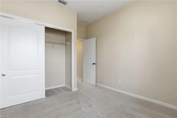 Unfurnished bedroom with light colored carpet and a closet