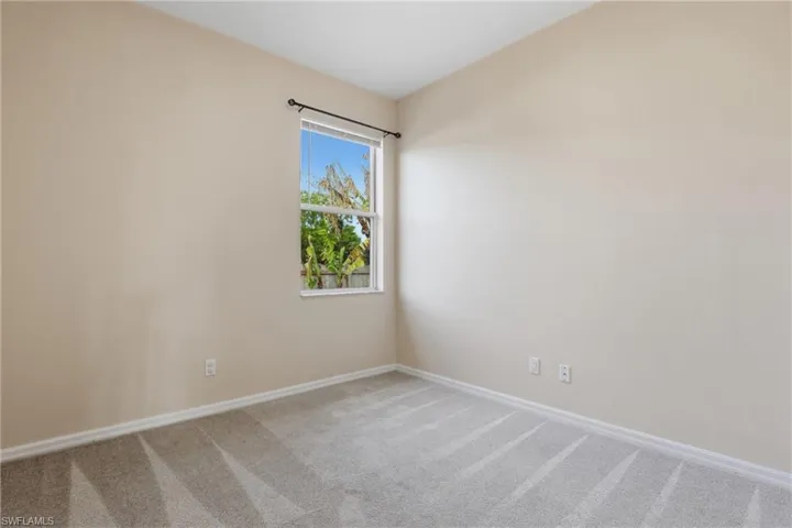 Spare room with light carpet and baseboards