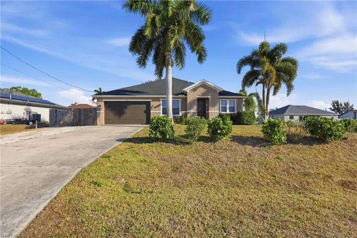 Ranch-style house featuring concrete driveway, an attached garage, and stucco siding