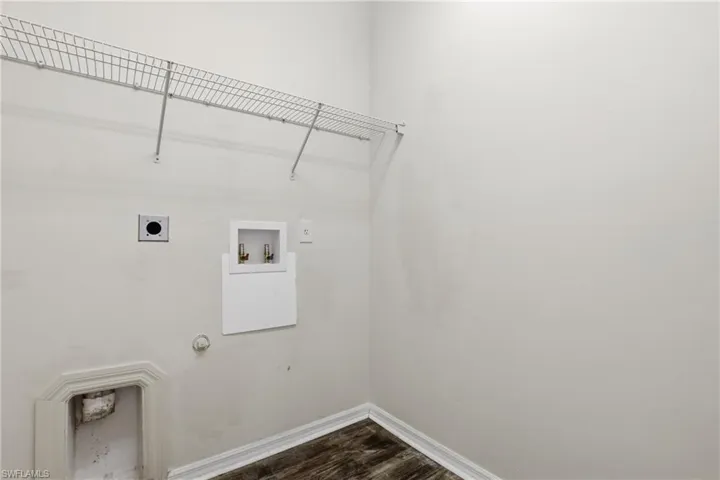 Laundry area with dark wood-style floors, hookup for a washing machine, gas dryer hookup, and hookup for an electric dryer