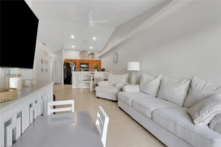 Hall featuring vaulted ceiling and light tile patterned floors