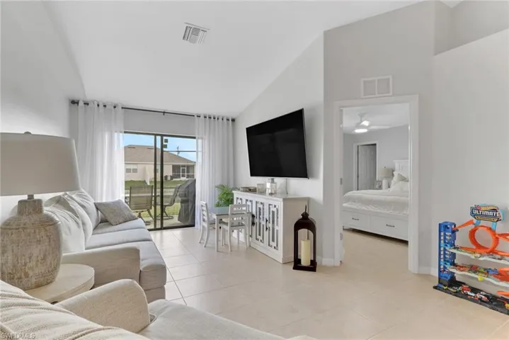 Living room featuring lofted ceiling and light tile patterned flooring
