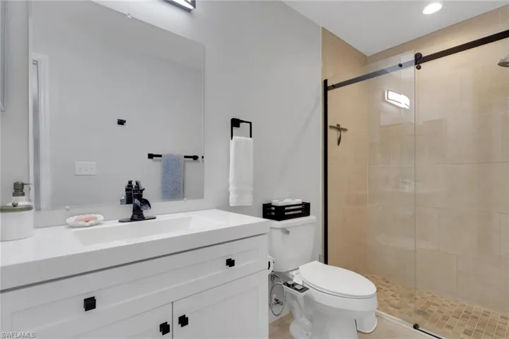 Full bathroom featuring vanity, a stall shower, and light tile patterned floors