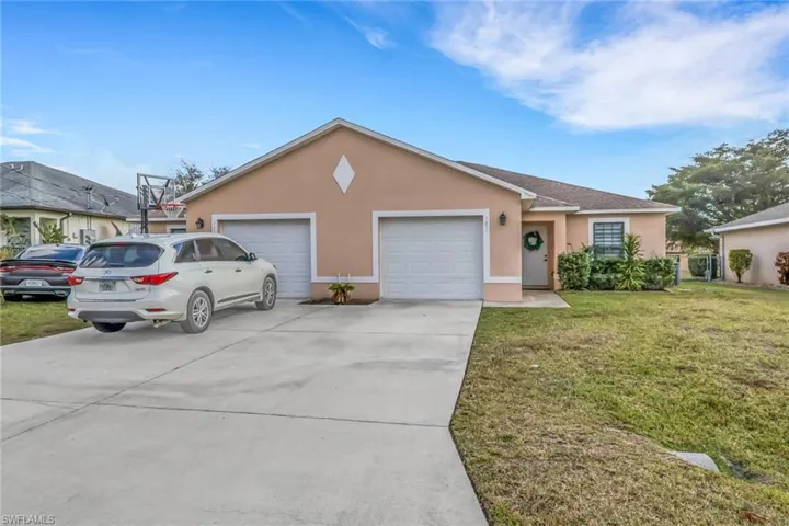 Ranch-style home featuring stucco siding, driveway, a front lawn, and a garage