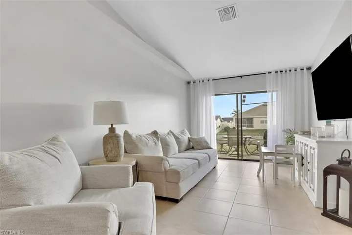 Dining area featuring vaulted ceiling, ceiling fan, and light tile patterned floors