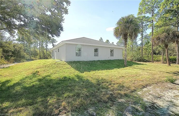 View of side of property featuring a yard and stucco siding