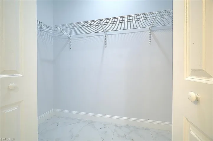 Walk in closet with marble finish flooring