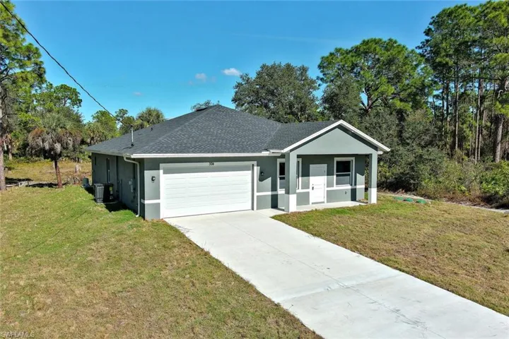 Single story home with stucco siding, an attached garage, a front yard, and roof with shingles