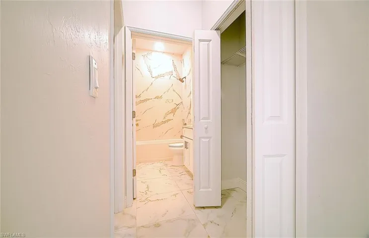 Hallway featuring light marble finish floors