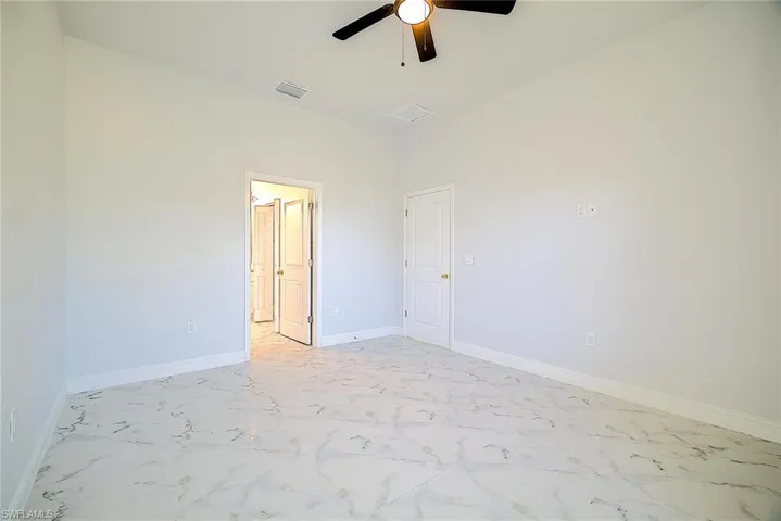 Unfurnished bedroom with a ceiling fan and light marble finish flooring