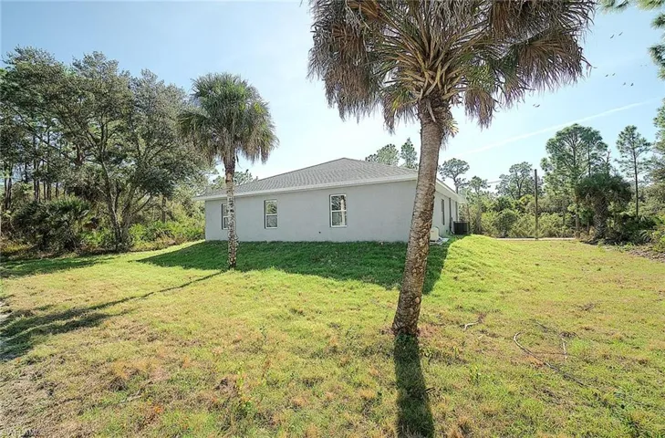 View of side of home featuring stucco siding and a yard