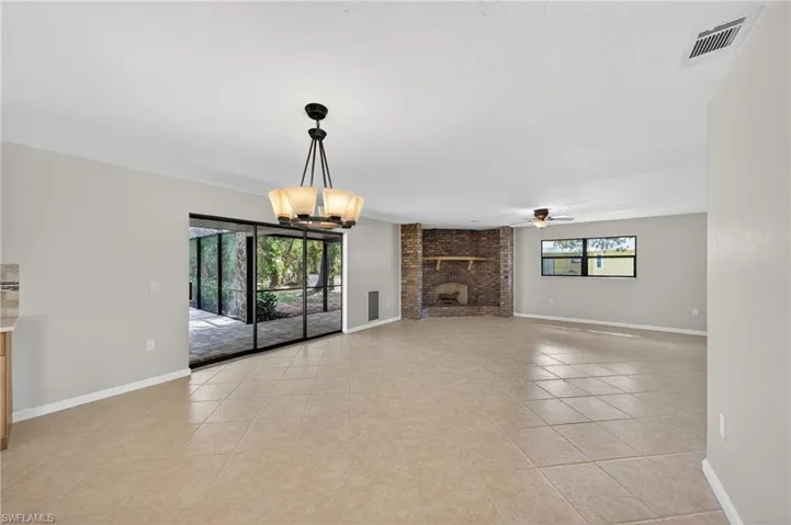 Spacious interior featuring large format tile flooring and a decorative chandelier