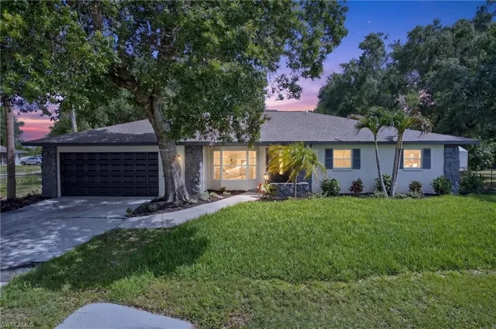 Single-story residence featuring a gray shingle roof and a two-car garage
