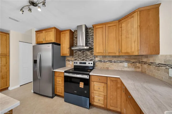 Kitchen featuring light wood cabinetry and a tiled backsplash