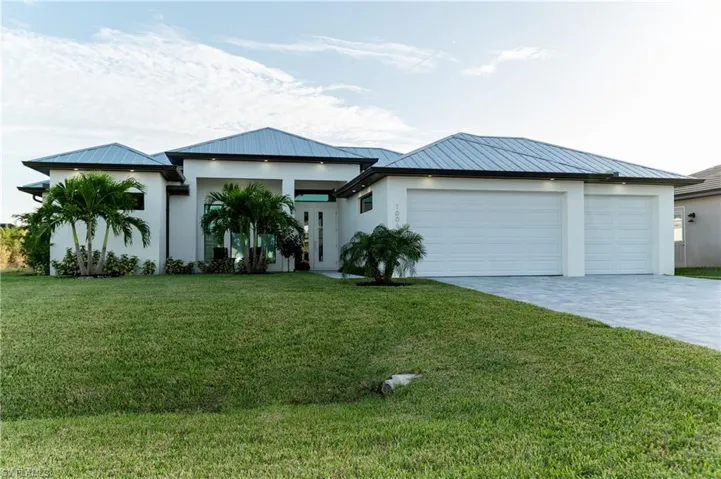 View of front of property with a front yard and a garage