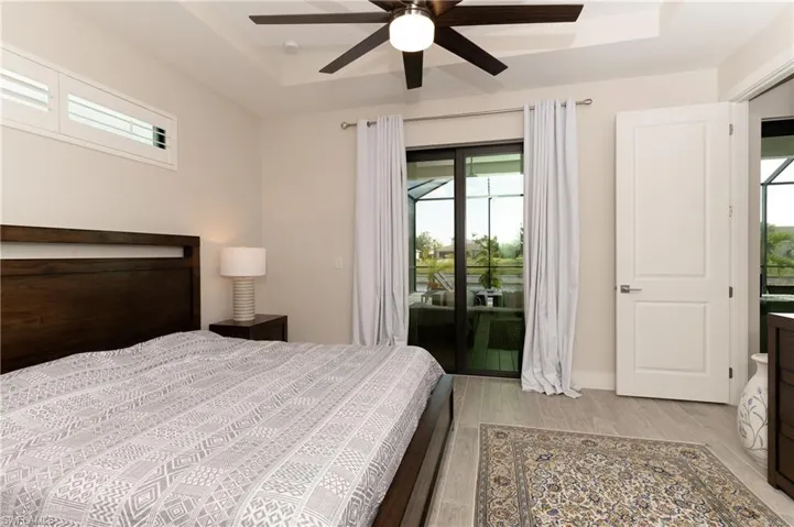 Bedroom with ceiling fan, light hardwood / wood-style floors, and access to exterior
