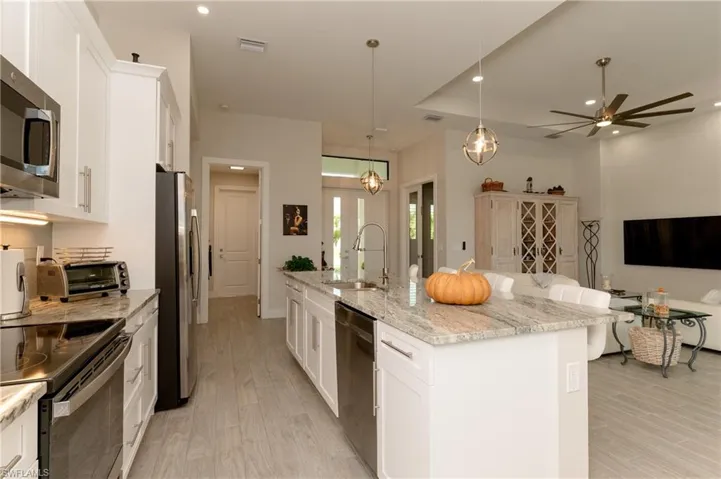 Kitchen with white cabinetry, a kitchen island with sink, sink, and stainless steel appliances