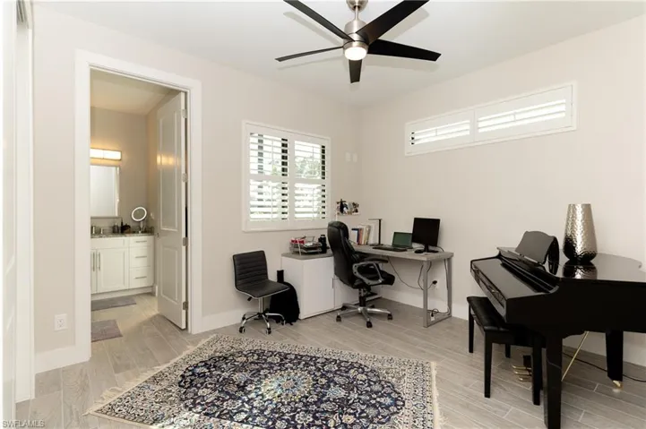Home office with ceiling fan and light wood-type flooring