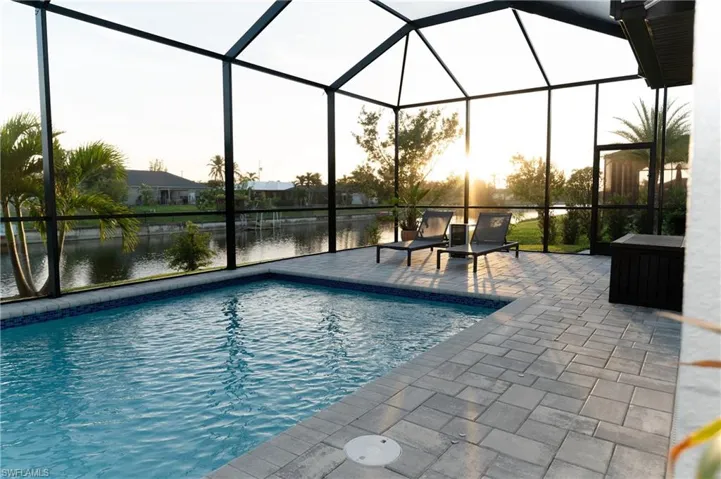 View of pool featuring a patio, a water view, and a lanai