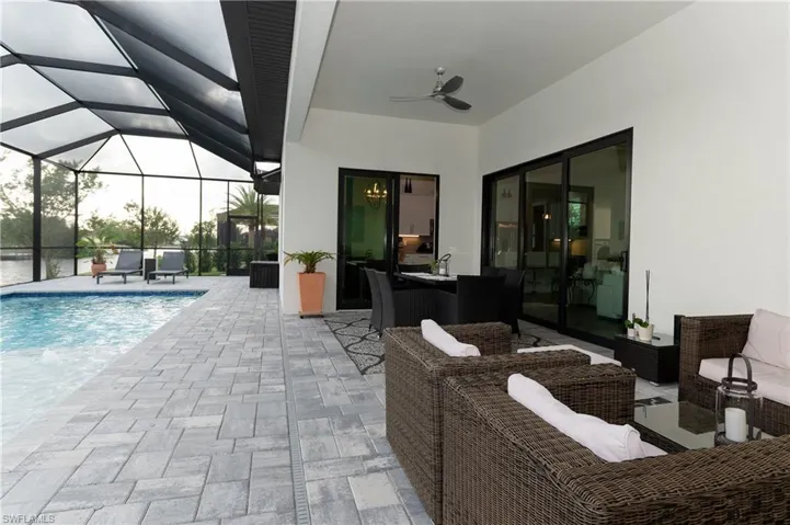 View of pool with a lanai, outdoor lounge area, a patio area, and ceiling fan