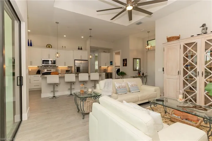 Living room with washer and dryer, light hardwood / wood-style flooring, and ceiling fan