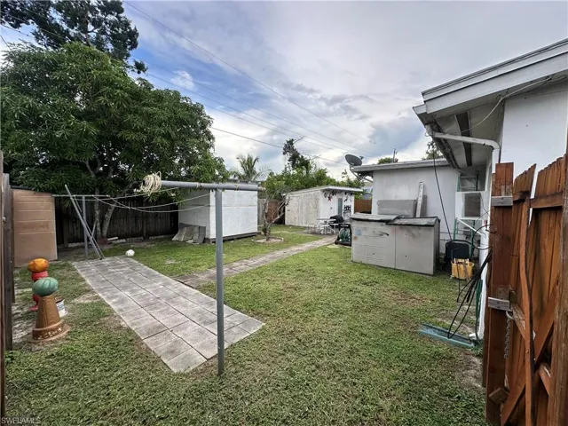 Fenced backyard featuring a shed