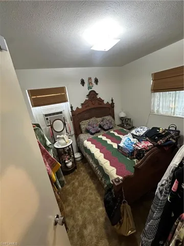 Bedroom featuring a textured ceiling and carpet floors