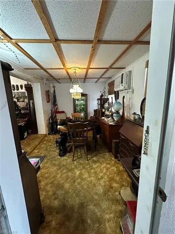 Carpeted dining area with an AC wall unit