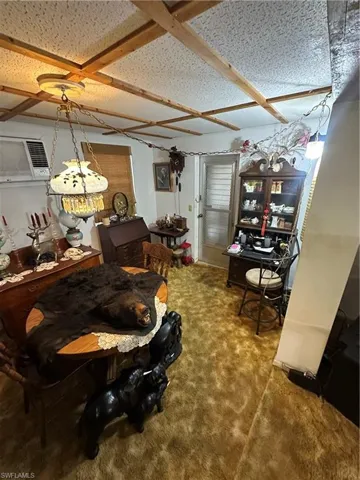 Dining area with carpet floors and a wall mounted AC
