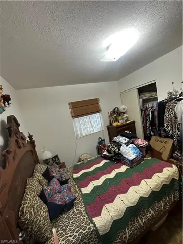 Bedroom with a textured ceiling and a closet